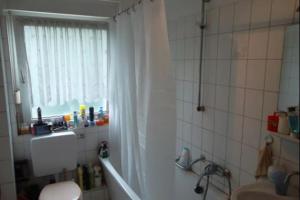 a bathroom with a shower and a toilet and a window at Düsseldorf - separates, privates Zimmer in Düsseldorf
