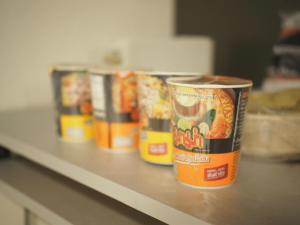 a row of cans of food sitting on a counter at Krung Tone Hostel in Bangkok