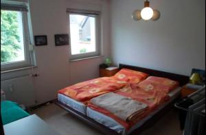 una camera da letto con un letto con una coperta rossa sopra di Düsseldorf - separates, privates Zimmer a Dusseldorf