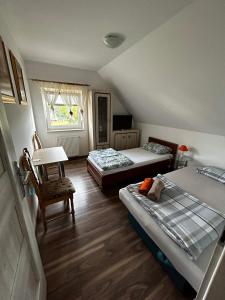 een kamer met 2 bedden en een tafel en een stoel bij Agroturystyka u Krystyny in Moryń