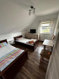 1 Schlafzimmer mit 2 Betten, einem Tisch und einem Fenster in der Unterkunft Agroturystyka u Krystyny in Moryń