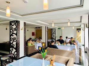 a group of people sitting at tables in a restaurant at Vina Hotel Hue in Hue