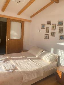 a bedroom with a large bed with a window and pictures on the wall at Robinson Sunset Guest House in Ohrid