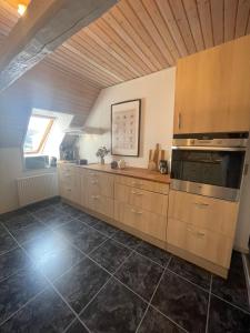 a large kitchen with wooden cabinets and an oven at Landligt ophold på Midtgård in Vamdrup