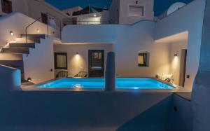 a villa with a swimming pool at night at Alaya Suites in Pirgos