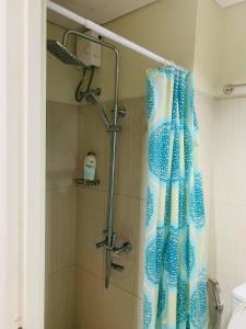 a shower with a blue shower curtain in a bathroom at Kathys crib 32sqm Condo Shell Residences in Manila