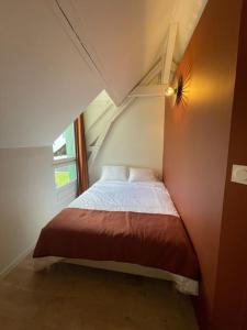małe łóżko w małym pokoju z oknem w obiekcie Maison du Thabor w mieście Rennes
