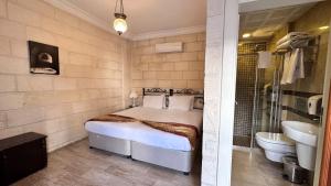 a bedroom with a bed and a tub and a sink at Mardin Konak Osmanlı in Mardin +38 photos