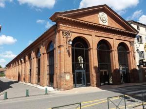 Studio - Centre de Villefranche de Lauragais في فيلفرانش-دو لوراجيه: مبنى من الطوب فوقه ساعة +3 صور