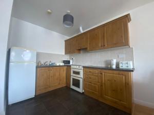 a kitchen with wooden cabinets and a white refrigerator at Two bedroom apartment in Ennis v95D854 in Ennis