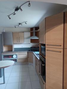 eine Küche mit Holzschränken und einem Tisch darin in der Unterkunft maison atypique proche mer forêts vallées in Vaudricourt