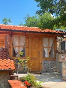 ein Haus mit einer Holztür und Fenstern in der Unterkunft Robinson Sunset Guest House in Ohrid