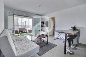 een woonkamer met een bed, een bureau en een tafel bij Apparemment T2 en résidence calme fermée in Marseille