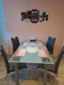 a dining room table with four chairs and a painting on the wall at Urlaub und Arbeit in Waldheim in Waldheim