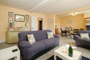 un soggiorno con divano viola e tavolo di Hill House Apartment a Framlingham