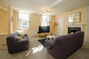 a living room with two couches and a television at Hill House Apartment in Framlingham