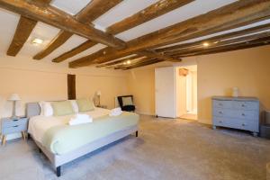 a bedroom with a bed and a dresser in a room at Hill House Apartment in Framlingham