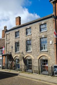 a brick building on the corner of a street at Hill House Apartment in Framlingham