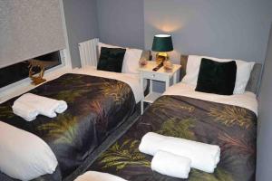Zimmer mit 2 Betten und einem Tisch mit einer Lampe in der Unterkunft Unique 4 Bed Home in Derby Perfect for Contractors! in Derby