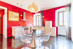una cucina con pareti rosse, tavolo e sedie di Steel house a Livorno
