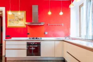 a red kitchen with a sink and a stove at Steel house in Livorno