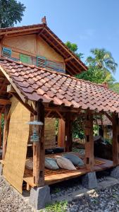 una casa de madera con techo encima en Omah Kepel Yogyakarta, en Soprayan