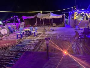a stage with chairs and a table and a tent at Gagal camp in Siwa
