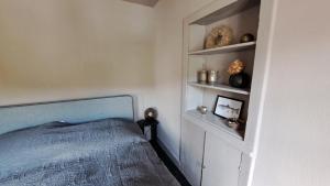 a bedroom with a blue bed and shelves at Ferienhaus Fridolin in Zell an der Mosel