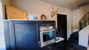 eine Küche mit einem Herd und einer Mikrowelle in der Unterkunft Ferienhaus Fridolin in Zell an der Mosel