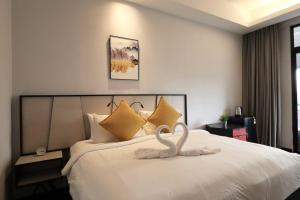 uma decoração de cisne numa cama num quarto de hotel em M101 KLCC KL city King Suites by Livin em Kuala Lumpur