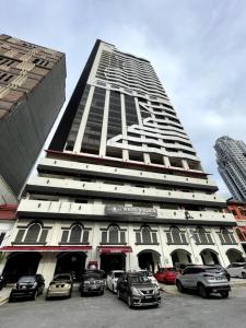 um edifício alto com carros estacionados em frente em M101 KLCC KL city King Suites by Livin em Kuala Lumpur