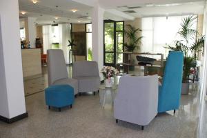 a lobby with chairs and a table with flowers at Hotel Acapulco in Forte dei Marmi