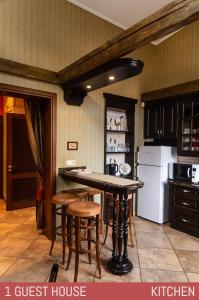 eine Küche mit einem Tisch und Stühlen sowie einem Kühlschrank in der Unterkunft Lielbrieži 8 in Skulte