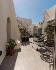 a patio with chairs and plants and a building at Alaya Suites in Pyrgos