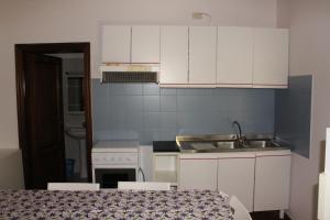 a small kitchen with white cabinets and a sink at Citrigni in Peschici +28 photos