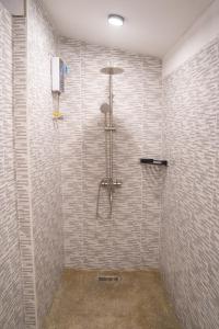 y baño con ducha y pared de azulejos. en K-Bunk Hostel Pai Walking Street en Pai