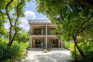 an exterior view of a house with trees at Ifuru Island Resort Maldives - 24-Hours Premium All-inclusive with Free Domestic Transfer in Raa Atoll