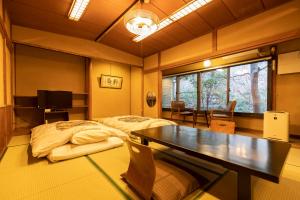 Habitación con cama y mesa. en Ryokan Hiyoshi, en Chichibu