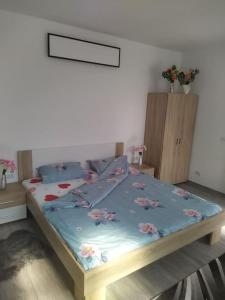 a bed with a blue comforter with flowers on it at Snoghoj,self check in,read listing in Fredericia