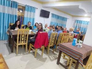 un grupo de personas sentadas en una mesa en Himalayan Regal House, en Deskit