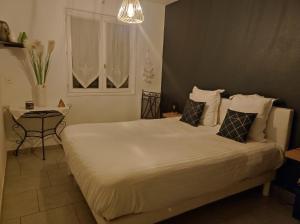 Un dormitorio con una gran cama blanca y una mesa en Landaise en Tarnos