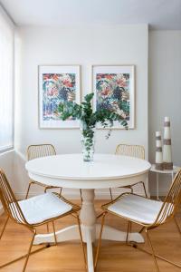 een witte eetkamer met een witte tafel en stoelen bij Misterhost Deluxe Santa Cruz I - cozy central and quiet in Sevilla