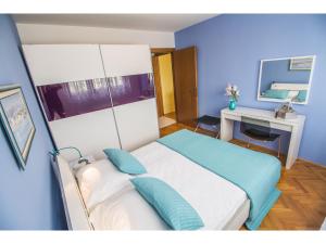 a blue bedroom with a bed and a desk at Apartment Seagull in Split