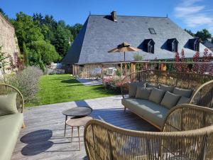 a patio with a couch and chairs and a house at LA MAISON 1788 in Meymac