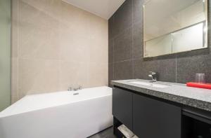 HOTEL MYEONG JAK في سوون: حمام مع حوض ومغسلة ومرآة