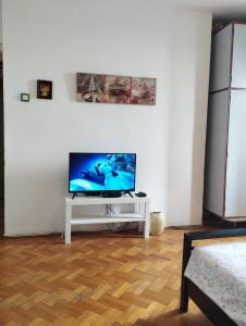 een woonkamer met een flatscreen-tv op een witte tafel bij Apartman Centar Beograd in Belgrado