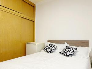 a bedroom with a bed with two pillows on it at Pensión el Carmen in Alcobendas
