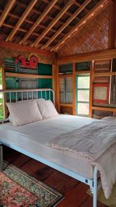 Cama grande en habitación con paredes de madera en Omah Kepel Yogyakarta, en Soprayan