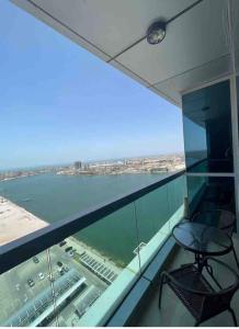 einen Balkon mit Stühlen und Blick auf das Wasser in der Unterkunft luxury studio with amazing seaview in Ras al Khaimah