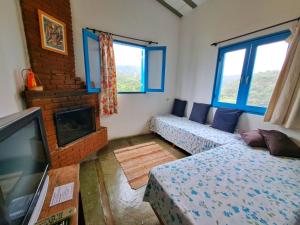 a living room with two couches and a tv at Pousada Vale das Araucárias in Santo Antônio do Pinhal